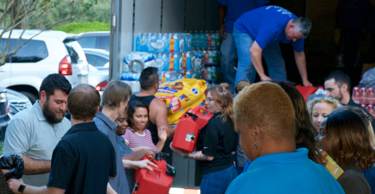 Health Insurance Innovations employees forming an assembly to load all the supplies onto the supply truck that will go to victims of Hurricane Michael